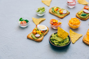 Top view of Freshly Homemade Guacamole with toast on rustic grey texture. Copy space.