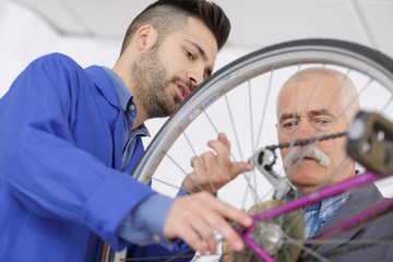 Obraz premium Men looking at bicycle chain