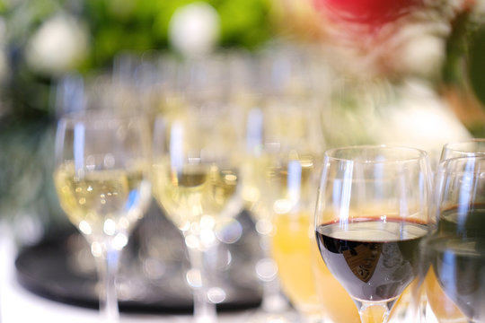 Glasses with red wine, juice and champagne on a serving table at a buffet table