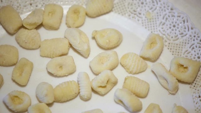 Preparazione degli gnocchi di patate fatti in casa a mano su un tagliere di legno
