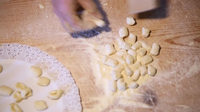 Preparazione degli gnocchi di patate fatti in casa a mano su un tagliere di legno