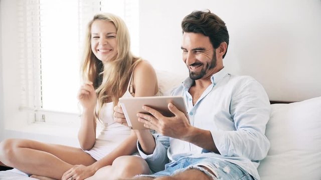 Couple sitting on sofa with touchpad