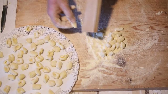 Preparazione degli gnocchi di patate fatti in casa a mano su un tagliere di legno