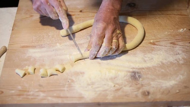 Preparazione degli gnocchi di patate fatti in casa a mano su un tagliere di legno