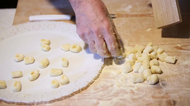 Preparazione degli gnocchi di patate fatti in casa a mano su un tagliere di legno