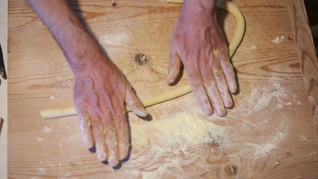 Preparazione degli gnocchi di patate fatti in casa a mano su un tagliere di legno