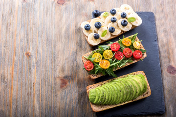 Vegan rye wholegrain sandwich with avocado, arugula, banana and blueberries for healthy meal, vitamin and diet food