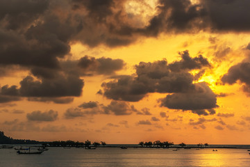 Sunset, the sea waves, fishing boat