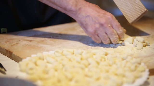 Preparazione degli gnocchi di patate fatti in casa a mano su un tagliere di legno