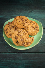 A teal plate of chocolate chips cookies with copyspace