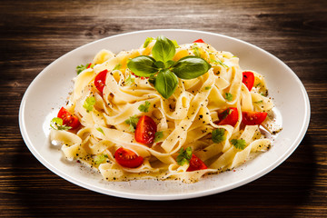 Pasta with tomatoes on wooden table