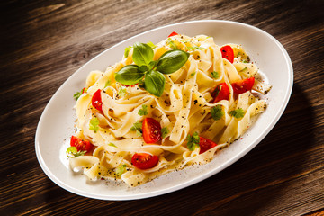 Pasta with tomatoes on wooden table