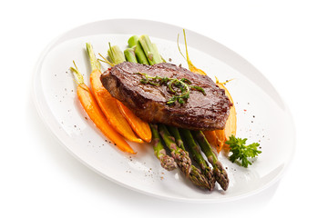 Grilled beefsteak with asparagus and carrot on white background
