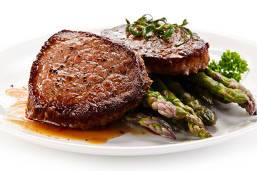 Grilled beefsteak with asparagus on white background
