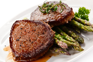Grilled beefsteak with asparagus on white background