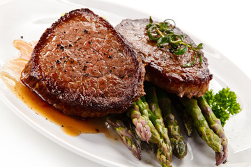 Grilled beefsteak with asparagus on white background
