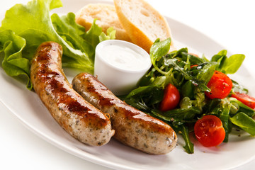 Grilled sausages with vegetables on white background