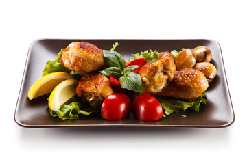 Roast chicken drumsticks on white background