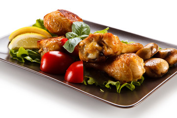 Roast chicken drumsticks on white background