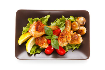 Roast chicken drumsticks on white background