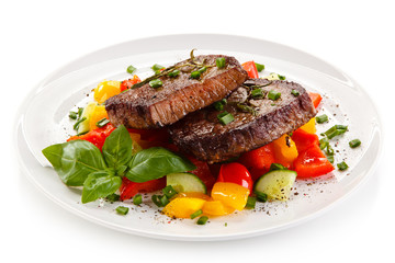 Grilled beefsteak with vegetables on white background