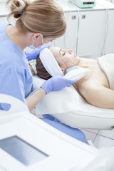 Young beautiful woman in the beauty salon on the face treatment