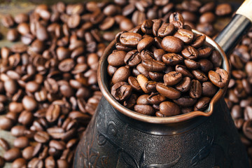 Copper coffee pot for preparation of coffee on  scattered coffee grains
