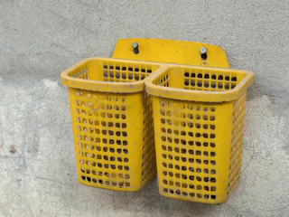 Fototapeta premium COLOR PHOTO OF PLASTIC BASKET SCREWED ON CONCRETE WALL