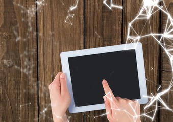 Overhead of hands with tablet and white network overlay