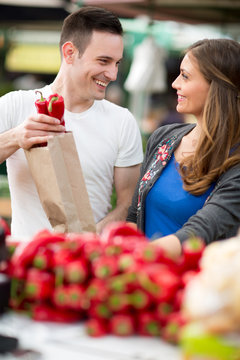 Couple choosing pepper in grocery store.