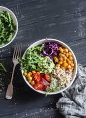 Quinoa and spicy chickpea vegetable vegetarian buddha bowl. Healthy food concept. On a dark background, top view