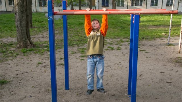 little child try pull up on the horizontal bar
