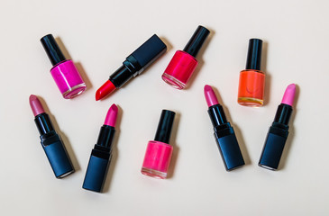 Obraz premium Set of lipsticks and nail polishes on beige background
