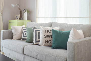 Fototapeta na wymiar Cozy gray sofa with geometry pattern pillows in modern living room