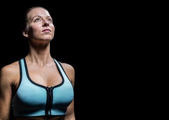 Female athlete looking up against black background