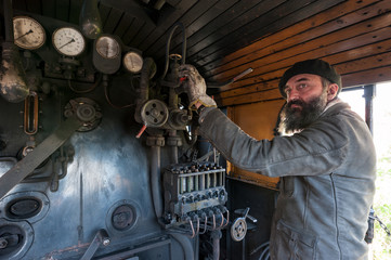 The train driver near the steam locomotive boiler
