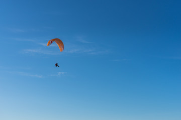 Parachutist over sky background