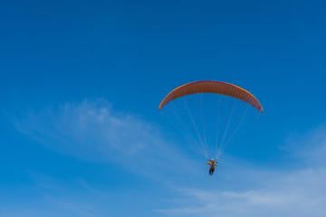 Parachutist over sky background