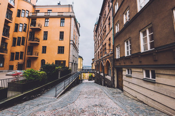 Old narrow street paved with cobblestone and apartment buildings in Brannkyrkagatan street in historic district Sodermalm in Stockholm, Sweden.