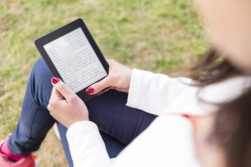 Attractive young woman with e-book/tablet in the park