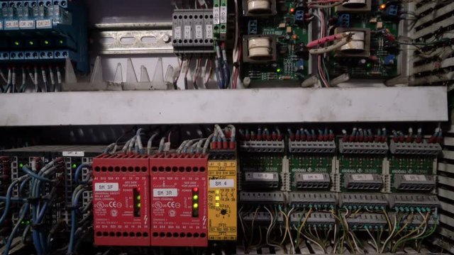 Tracking shot of electrical panel with fuses, relay, switches and contactors.