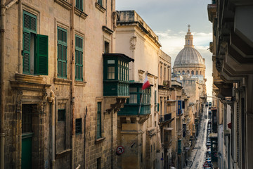 Narrow street of Valletta in the morning with a view of Basilica of Our Lady of Mount Carmel, Malta