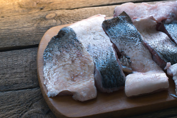 Raw fish with spices on a wooden board.