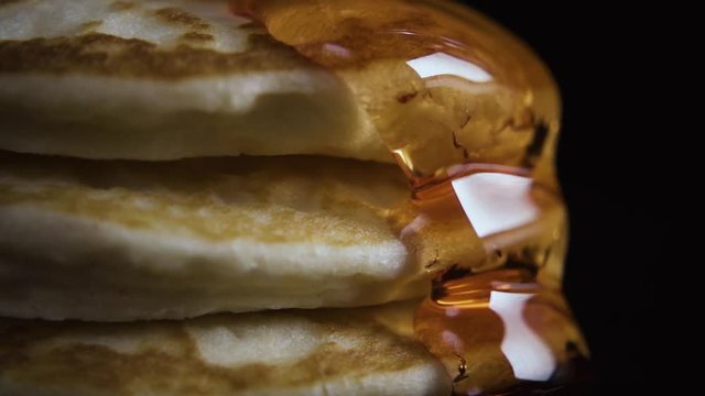 With three pancakes flowing maple syrup. Front view. Close-up. Slow mo
