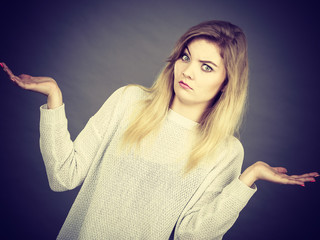 Confused young blonde woman gesturing with hands
