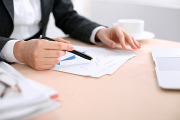 Business woman sitting at the table and examines the financial results