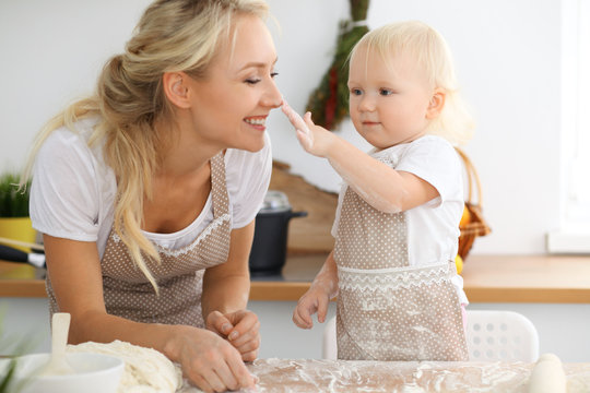 Mother And Her Little Daughter Cooking Holiday Pie Or Cookies For Mother's Day. Concept Of Happy Family In The Kitchen.