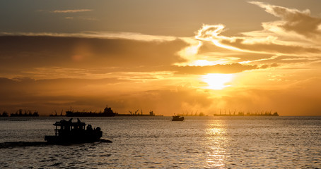 Silhouette of passenger ship at sea with sunset sky background