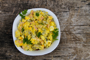 Russian traditional salad olivier on wooden table