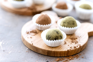 Two wooden board with homemade healthy vegan chocolate truffles rolled cocoa and matcha powder Copy space
